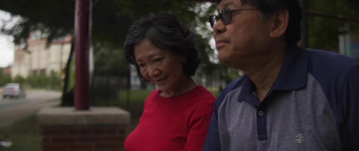A man and woman are outside in the park