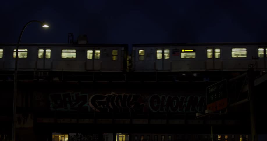 A passenger train drives through a city at night