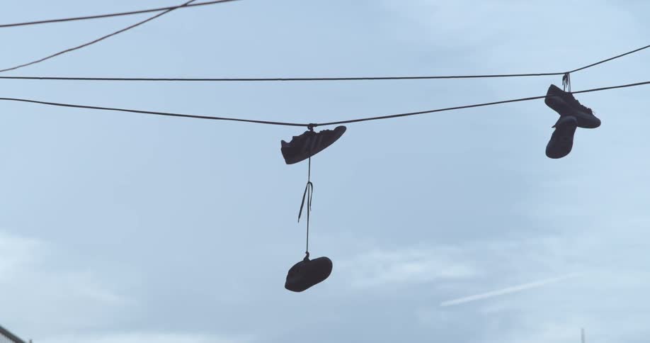 Shoes tied together and thrown over power cords