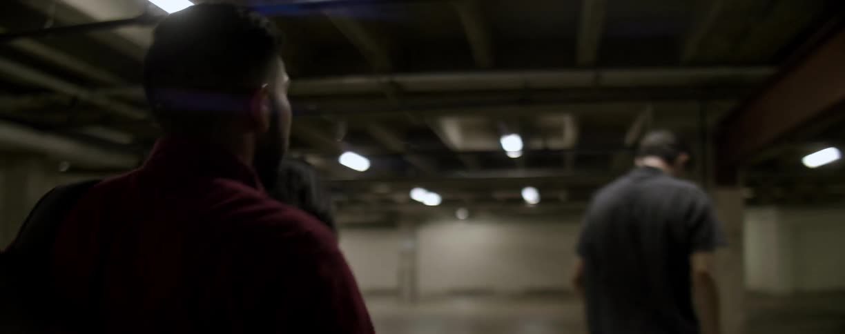 People walk fast through underground parking garage