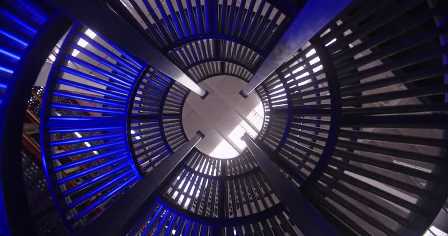 A static low angle shot looking up from inside a modern, circular conveyor belt system in an industrial factory
