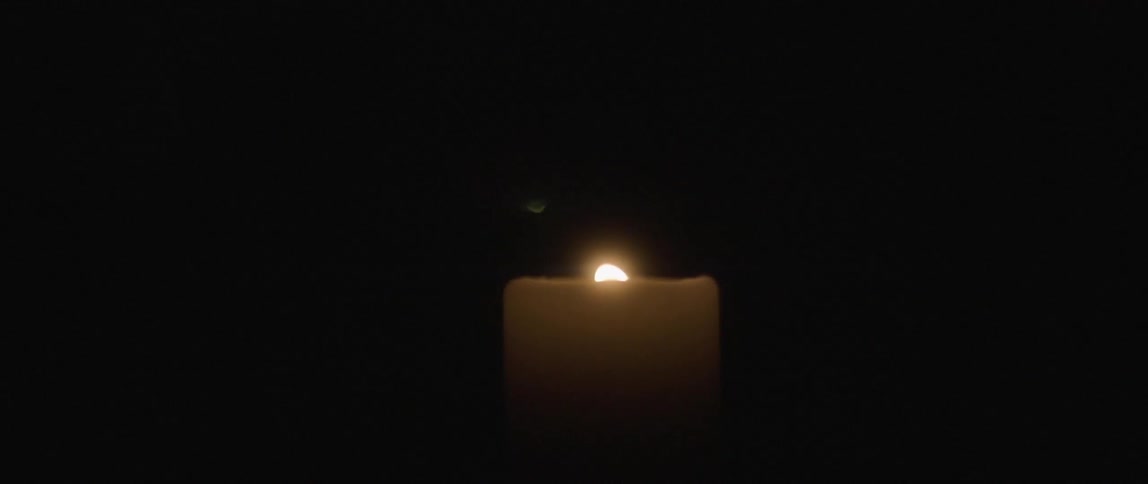 Candle flame dances slowly in the dark