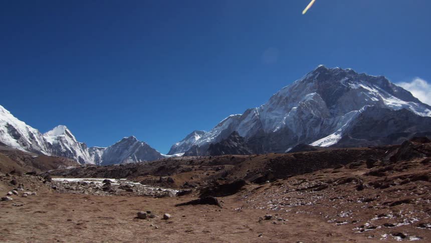 Hikers walk in the snowy mountains on a sunny day