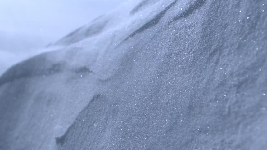 A magical close-up of a pristine snowdrift shows tiny ice crystals sparkling and glittering in the light