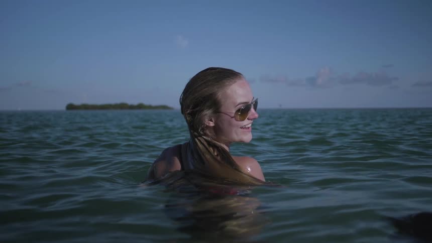 A woman turns around in the water smiling