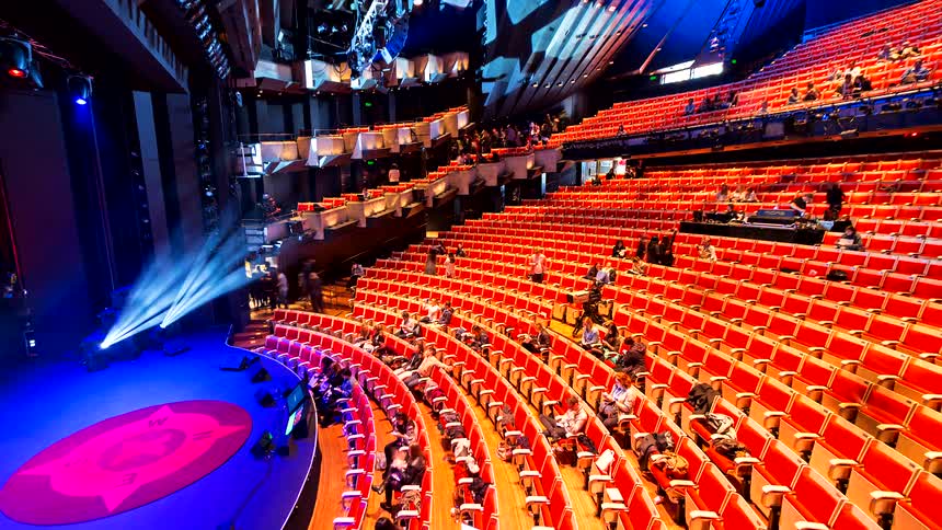 A high-angle timelapse shows a crowd emptying out of a vibrant concert hall after a show