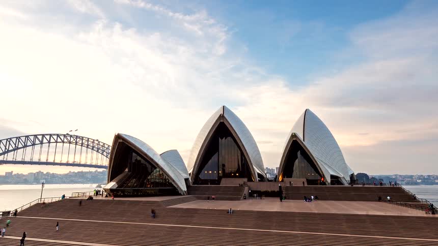 A beautiful day-to-night time-lapse of the iconic Sydney Opera House and Harbour Bridge with a slow zoom out