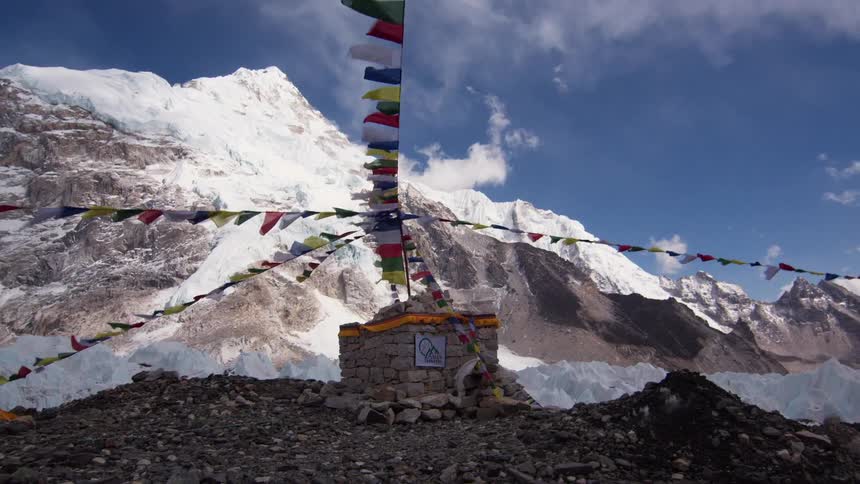 Flags waving in front of a snowy mountain