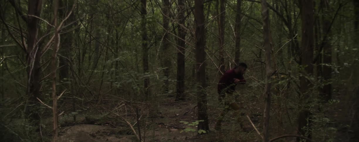 A man moves fast through the trees