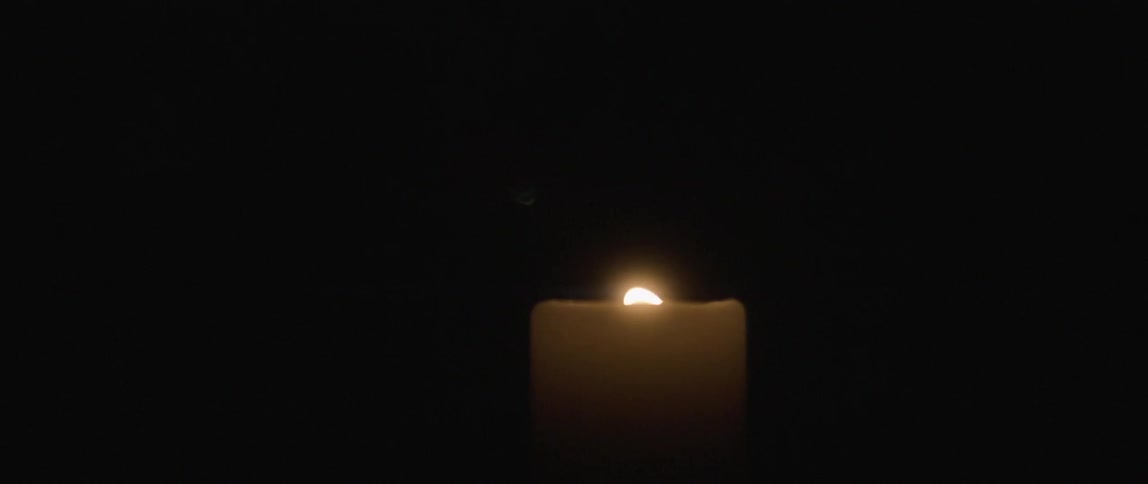 Candle flame flickering in the darkness