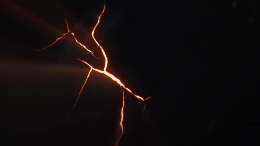 Fiery orange cracks spread across a dark abstract background with emerging beams of light in this animation