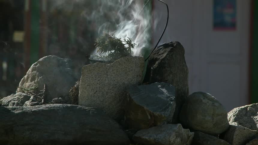 Smoke burning branches on top of rocks