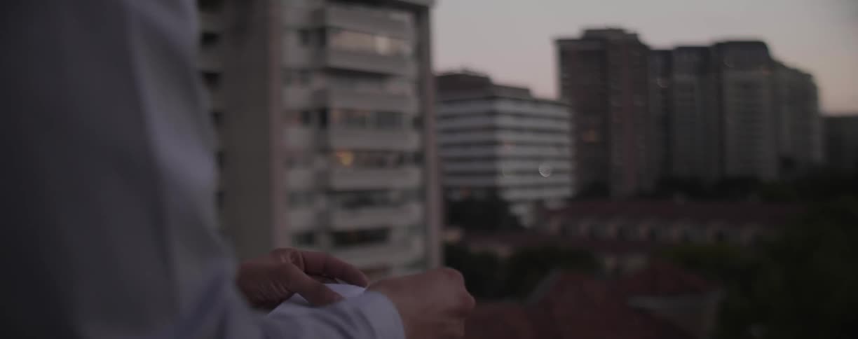 Person opens a letter on an apartment balcony