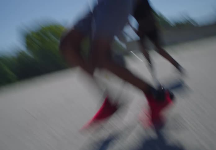 Dynamic footage captures a basketball player skillfully maneuvering past a defender to score a powerful dunk on a sunny outdoor court