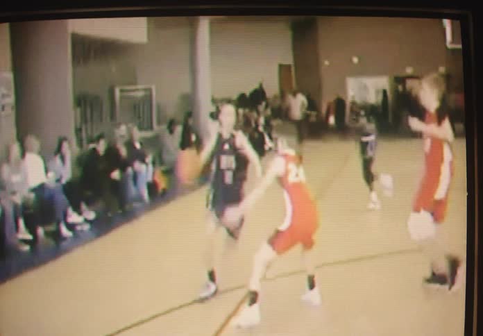 An old television screen displays vintage-style footage of a high school basketball game with players scoring points