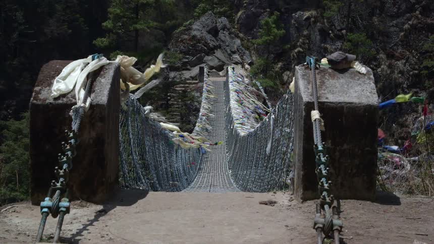 A canyon bridge is covered with pieces of fabric blowing in the wind