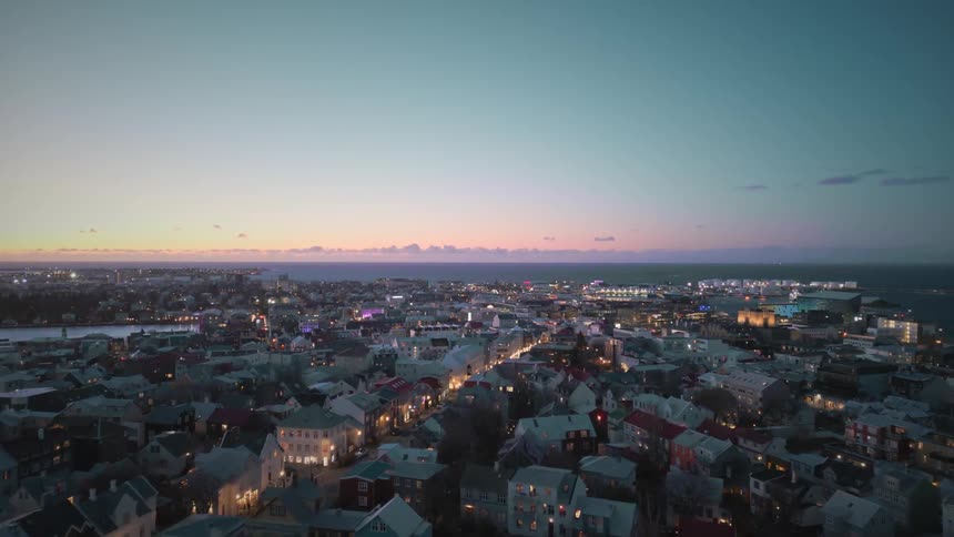 An establishing shot shows a wide, static timelapse of Reykjavik, Iceland, glowing with city lights at dusk