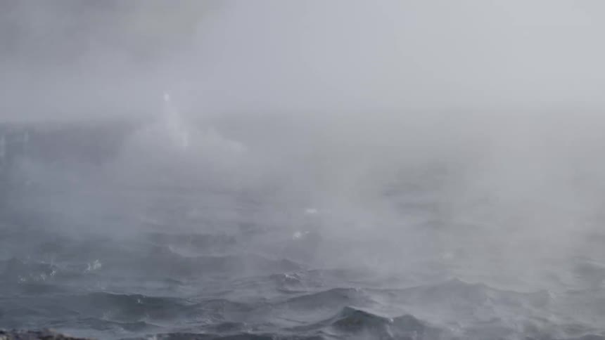 Ethereal slow motion close-up of a powerful geyser erupting amidst dense steam and boiling water