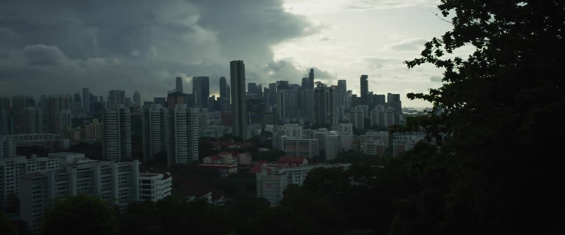 A moody, wide-angle view of the Singapore city skyline under a dark and cloudy sky