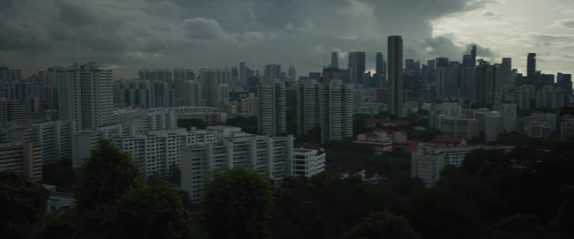 A dramatic pan across the moody Singapore cityscape reveals the downtown skyline under dark, stormy clouds