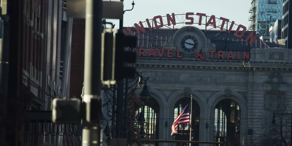 An American flag waves proudly in front of the iconic Union Station building in downtown Denver, Colorado