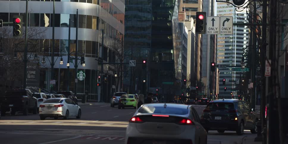 A slow motion shot of pedestrians and traffic at a crosswalk on a busy downtown city street