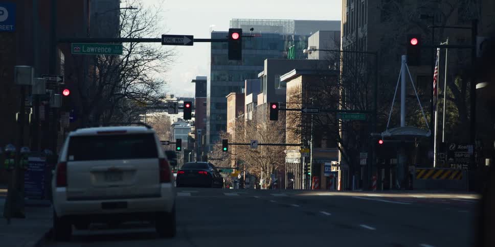 A quiet Lawrence Street in downtown Denver is nearly empty of traffic and pedestrians in the early morning light