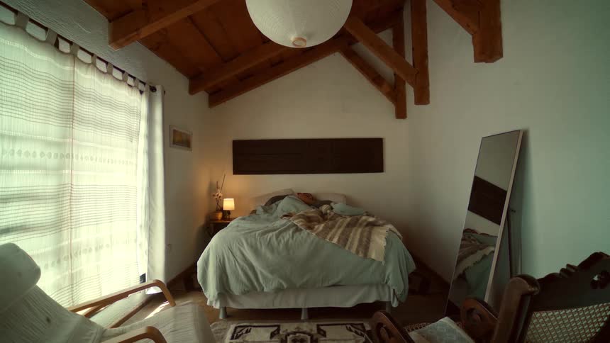 Timelapse of a person peacefully sleeping in a rustic bedroom as the morning light gradually brightens the room