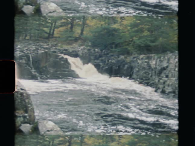 Vintage split-screen film captures a powerful waterfall cascading over rocky cliffs into a fast-flowing river