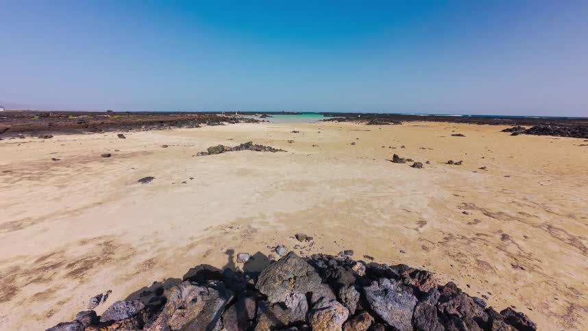 A stunning time-lapse captures the tide coming in over a sandy beach, transforming the landscape into a beautiful turquoise lagoon where people come to swim