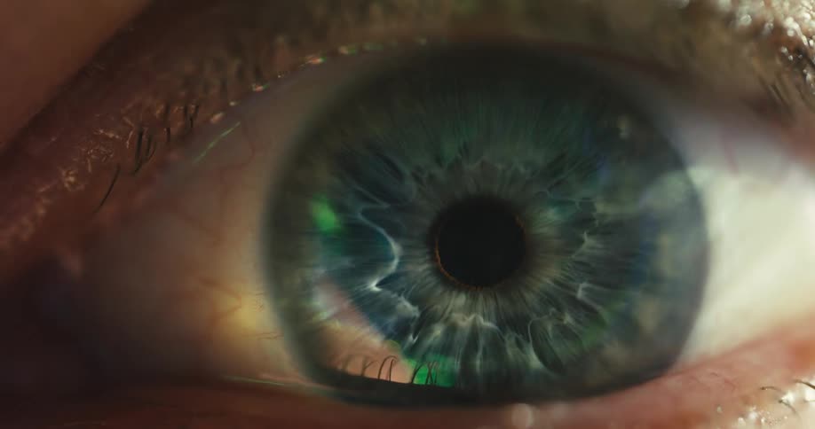 A mesmerizing extreme close-up of a human eye as light fades, revealing the intricate details of the iris and the dilation of the pupil