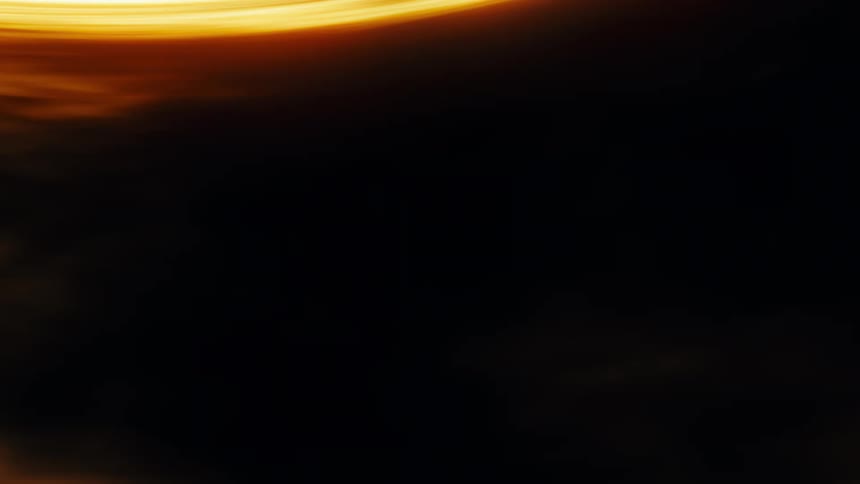 Abstract golden energy trails and light streaks flow in smooth, warm patterns across a dark background