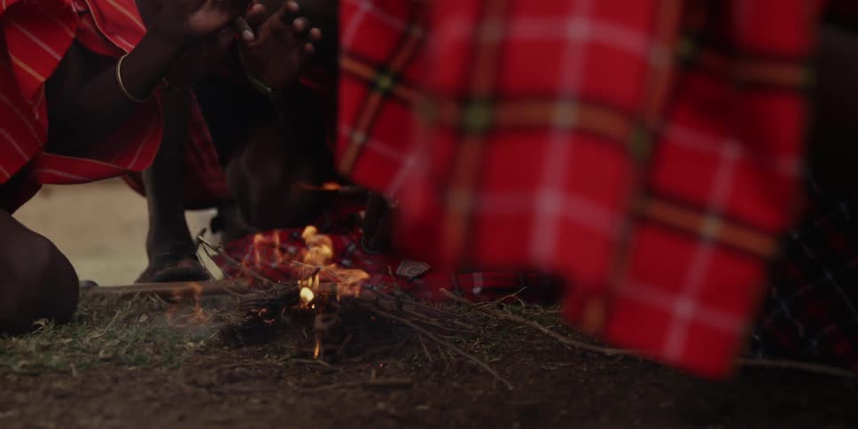 Person blowing and building a small fire