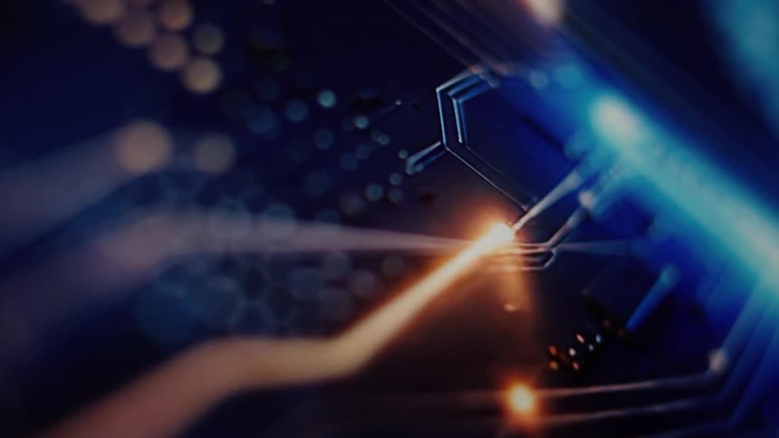 Glowing lines of orange light travel across a sophisticated blue circuit board in a shallow focus macro shot
