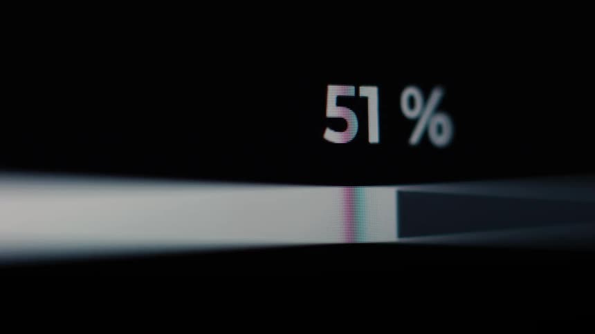 A close-up, macro shot of a white progress bar loading with the percentage increasing on a digital screen