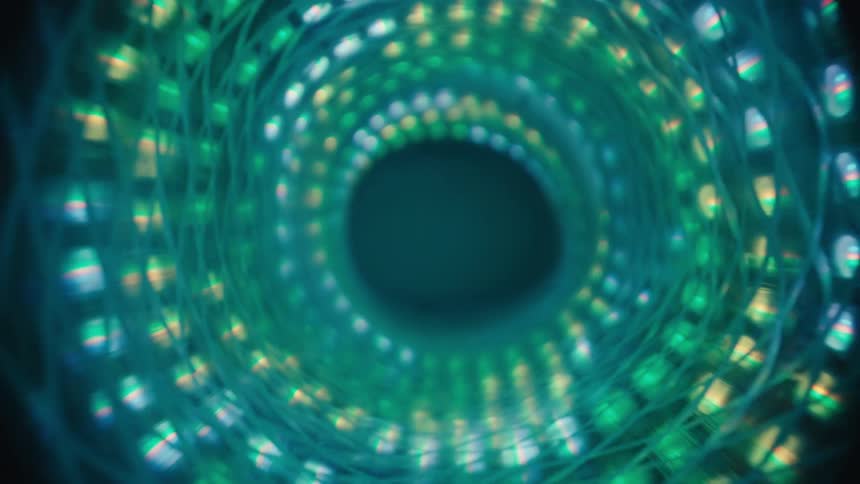 A slow zoom out of a mesmerizing, abstract vortex of glowing green and blue LED lights
