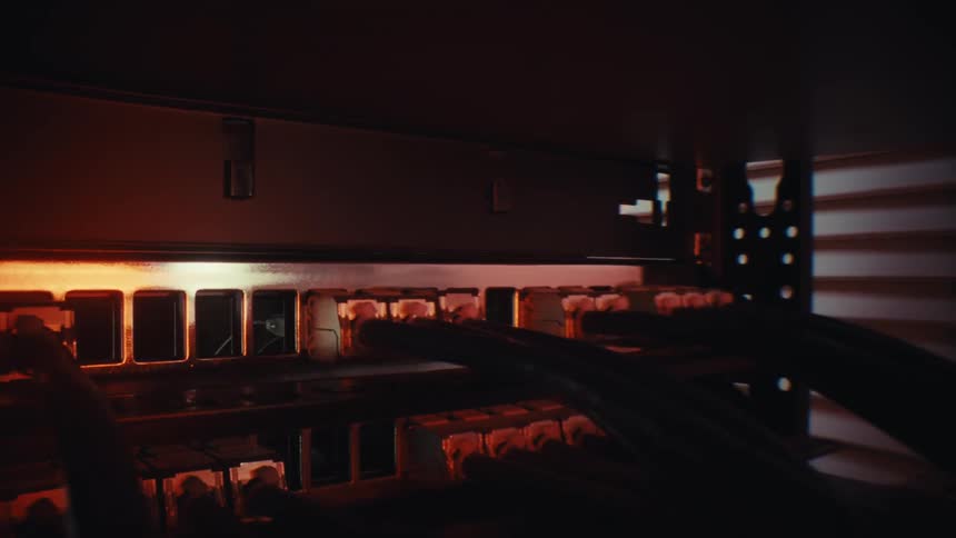 A cinematic pull-out shot reveals network ethernet cables plugged into a patch panel inside a dark server rack, illuminated by a dramatic warm light