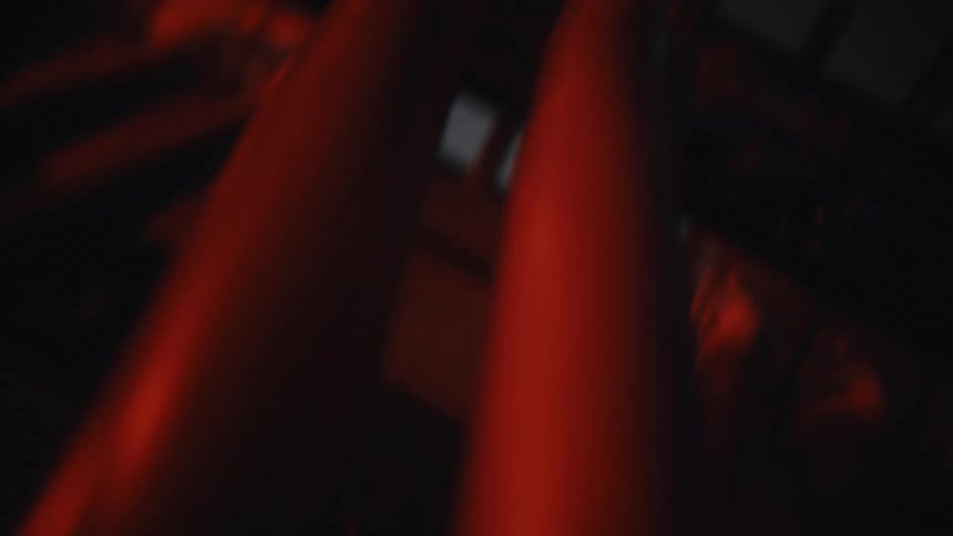 A macro camera moves across the glowing red ports of a network switch inside a dark server room