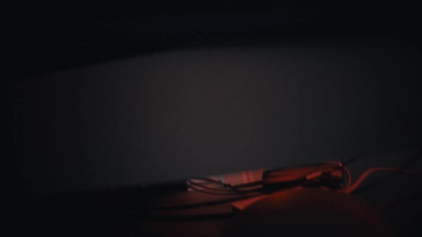 A camera slowly pans over ethernet cables plugged into a switch in a dark server room with red mood lighting
