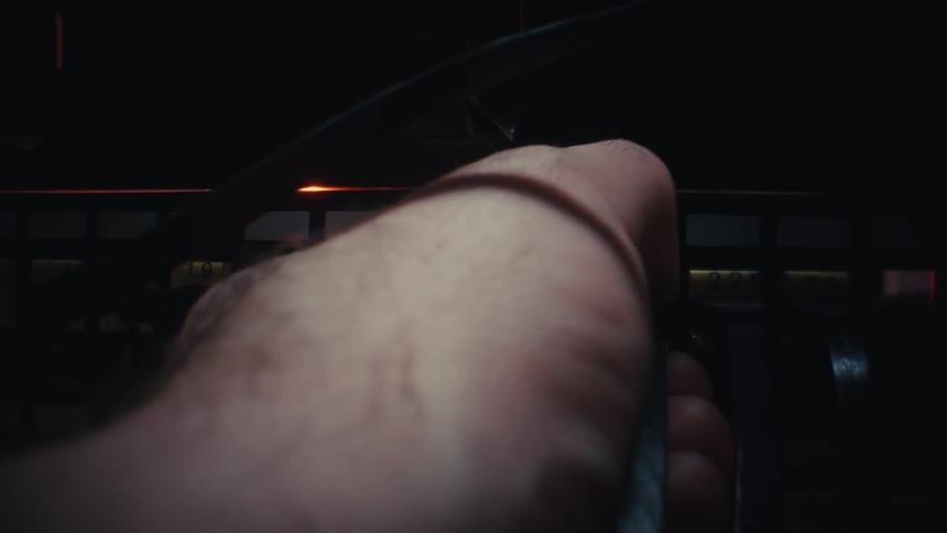 Close up of an IT technician plugging an ethernet cable into a network patch panel in a dark server room