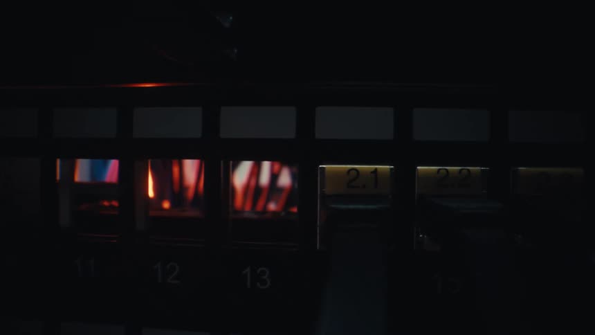 A hand unplugs an ethernet cable from a network switch in a dark server room in slow motion