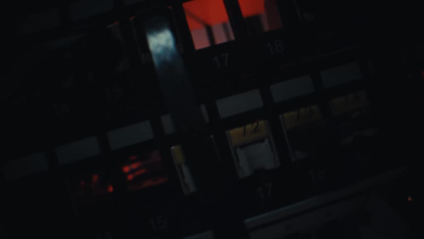 A close-up, angled shot reveals the blinking indicator lights of a server rack in a dark data center