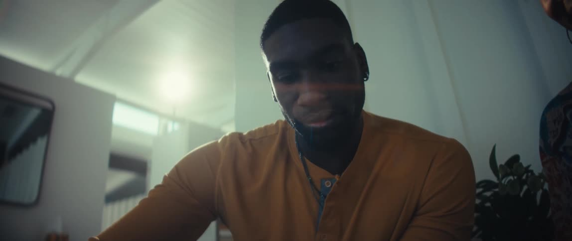 Low angle shot of a young Black couple looking at a tablet together in their modern, sunlit home