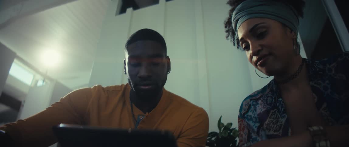 Close-up from a low angle of a focused young couple using a tablet computer at home