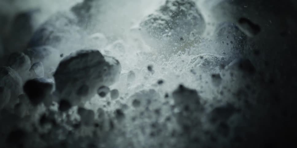 Mysterious white particles and powder bubble and dissolve in a dark liquid during a slow-motion chemical reaction