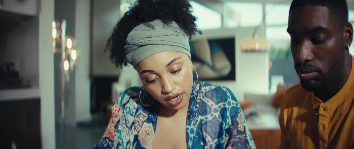 Close-up shot of a young black woman talking to a man while studying together at home
