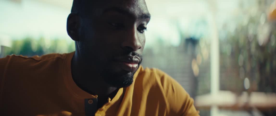 A young professional man listens intently while collaborating with a female colleague on a business report with charts