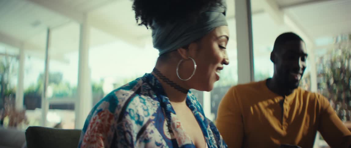 A young African American couple is filled with joy and excitement as they review their finances together at home