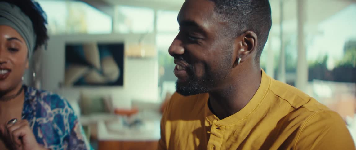 A happy young couple smiles and chats while looking over something together in their bright modern home