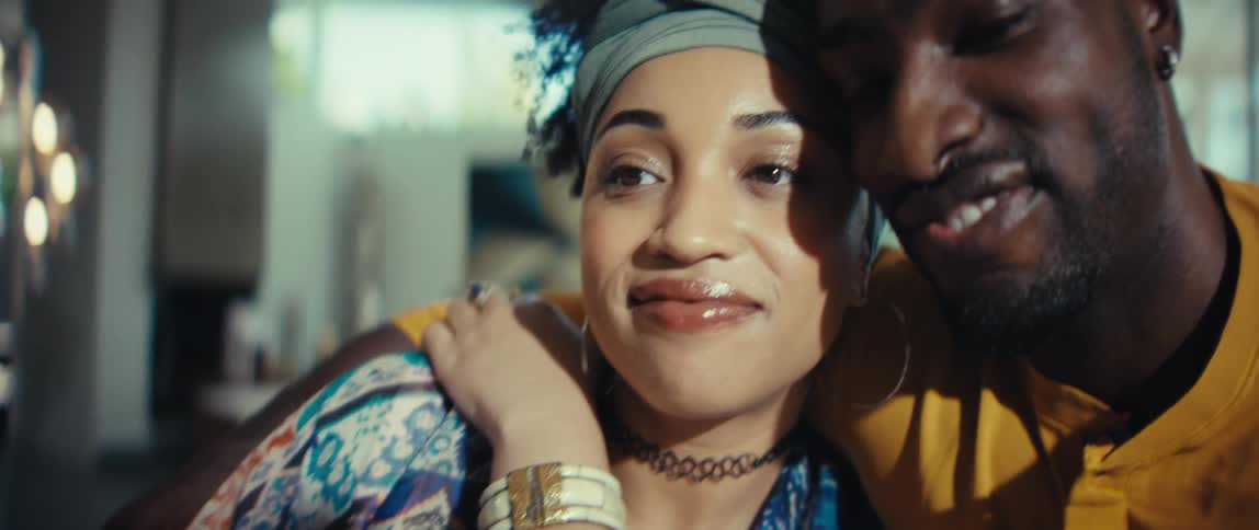 A beautiful African American couple shares a tender, smiling moment while cuddling close